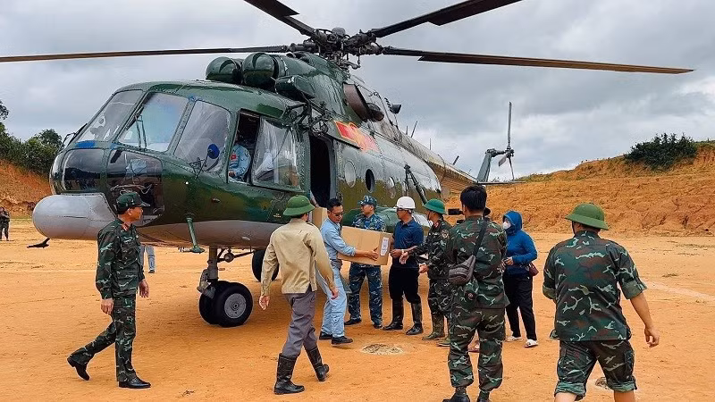Các lực lượng địa phương tiếp nhận hàng cứu trợ từ trực thăng vận chuyển về xã Tìa Dình, tỉnh Điện Biên. (Ảnh: LAN ANH)