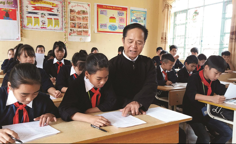 Nghệ nhân ưu tú Lâm Minh Sập dạy trẻ em trong xã hát dân ca Sán Chỉ. (Ảnh Nguyễn Hưởng) nghe-nhan-uu-tu-lam-minh-sap-day-tre-em-trong-xa-hat-dan-ca-san-chi-anh-nguyen-huong.jpg