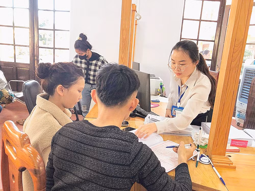 Cán bộ Trung tâm Phục vụ hành chính công xã Đức Trọng trả kết quả giải quyết thủ tục hành chính cho người dân.