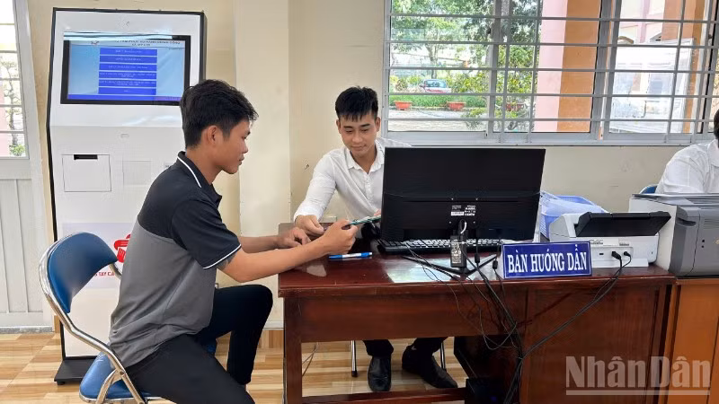 Cán bộ Trung tâm Phục vụ hành chính công xã Mỹ Lợi hướng dẫn người dân thao tác nộp hồ sơ trực tuyến. 