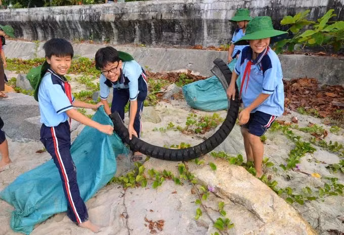 Các em học sinh cũng tích cực thu gom rác.
