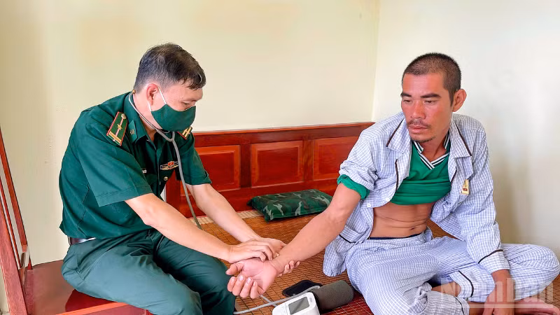 Quân y đồn Biên phòng Trung Bình thăm khám sức khỏe cho ông Lê Văn Ngoan. (Ảnh: VĂN LONG)