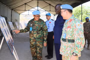 Đại diện Phái bộ An ninh Lâm thời Liên hợp quốc tại khu vực Abyei và chính quyền địa phương tìm hiểu chặng đường 81 năm chiến đấu và trưởng thành của Quân đội nhân dân Việt Nam qua không gian trưng bày sách lịch sử quân sự Việt Nam. (Ảnh: VĂN QUYẾT)