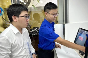 Cán bộ Trung tâm Đăng ký giao dịch, tài sản (thuộc Cục Đăng ký giao dịch bảo đảm và Bồi thường nhà nước, Bộ Tư pháp) hướng dẫn người dân làm hồ sơ trên Hệ thống đăng ký trực tuyến.