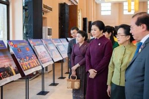 Bà Ngô Phương Ly và bà Naly Sisoulith cùng các khách mời tham quan khu vực Triển lãm ảnh quan hệ Việt Nam-Lào. (Ảnh: Nguyễn Hồng)
