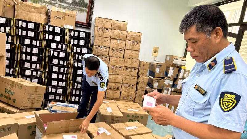 Lực lượng Quản lý thị trường thành phố Hà Nội kiểm tra một cơ sở kinh doanh hàng hóa có dấu hiệu vi phạm. (Ảnh: LƯU QUYÊN)