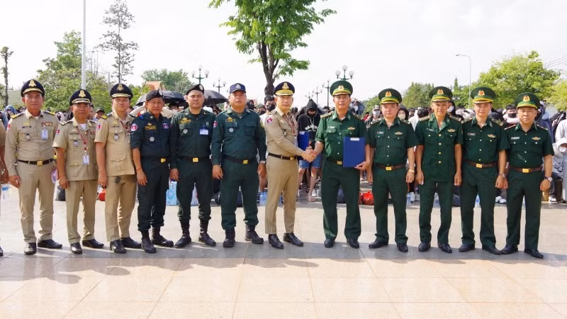 Lực lượng chức năng Campuchia và Đồn biên phòng cửa khẩu quốc tế Hoa Lư ký biên bản bàn giao công dân Việt Nam tại cột mốc 69. (Ảnh: TTXVN)