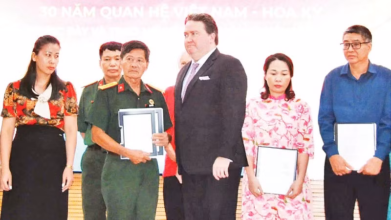 Cựu Đại sứ Hoa Kỳ tại Việt Nam Marc Knapper trao trả hồ sơ thời chiến cho đại diện Ban liên lạc Đoàn công tác chính sách quy tập hài cốt liệt sĩ Sư đoàn 308 và các thân nhân liệt sĩ.