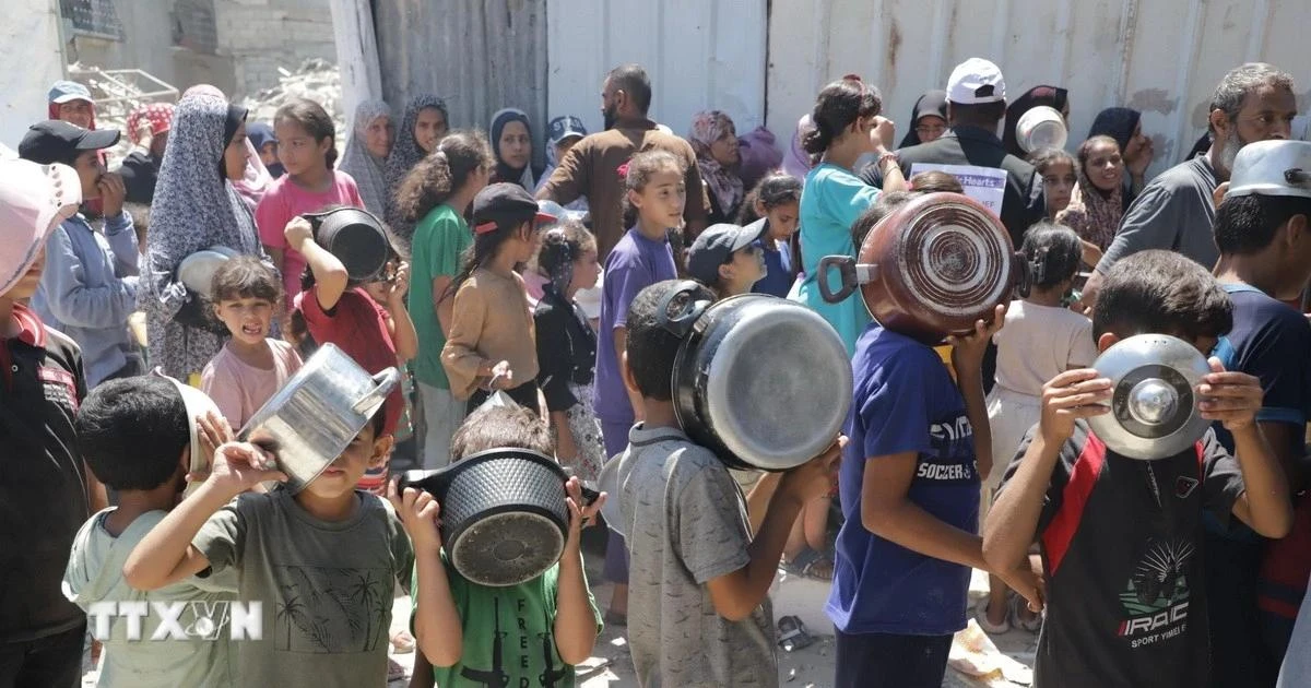 Trẻ em xếp hàng nhận thức ăn cứu trợ tại trại tị nạn Jabalia ở Dải Gaza. (Ảnh: THX/TTXVN)