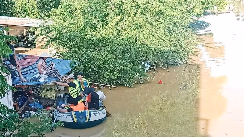 Lũ ngập đến mái nhà, lực lượng cứu hộ đón vợ anh Ngô Văn Hùng ở tổ 17, phường Phan Đình Phùng đến nơi an toàn. 