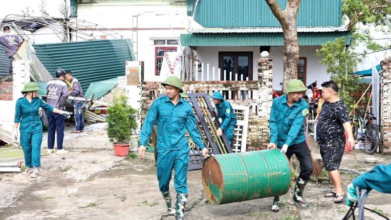Cán bộ, chiến sĩ Ban Chỉ huy quân sự xã Đầm Hà (Quảng Ninh) giúp nhân dân khắc phục hậu quả do giông lốc gây ra.