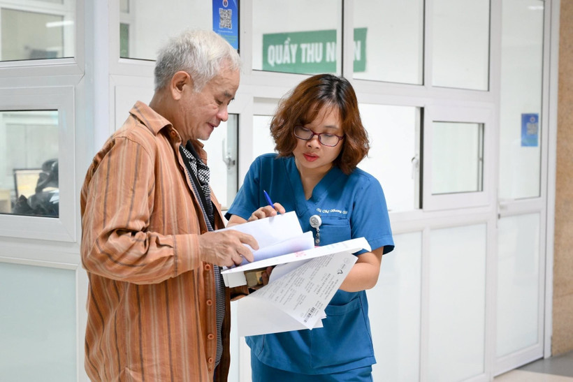 Bác sĩ Bệnh viện Thanh Nhàn, Hà Nội hướng dẫn bệnh nhân đến các phòng chuyên môn. (Ảnh THẾ ĐẠI)