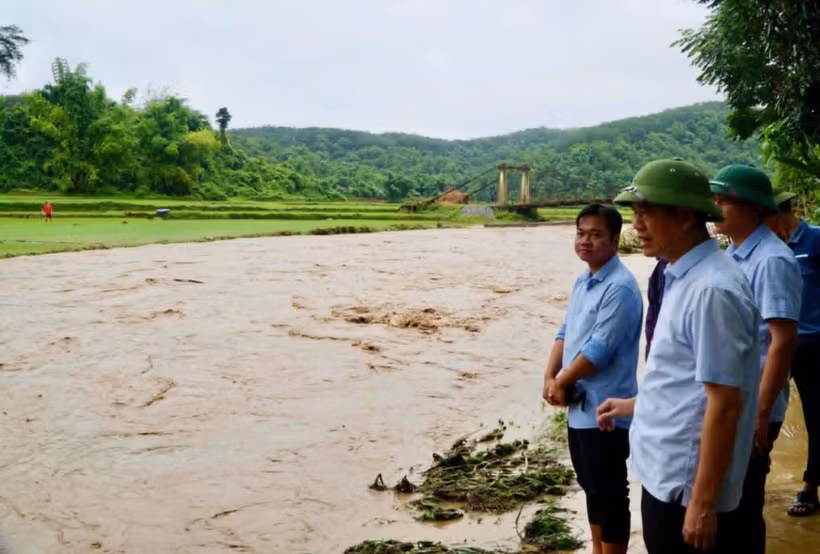 Ông Nguyễn Thái Bình (phía trước, bên phải ảnh) kiểm tra tình hình mưa lũ tại địa bàn. (Ảnh Lan Lê)