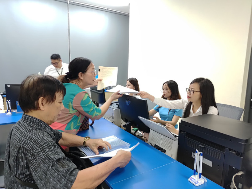 Điểm phục vụ hành chính công xã Thanh Trì (Hà Nội) hướng dẫn người dân làm thủ tục mua bán bất động sản. (Ảnh VĂN HỌC)
