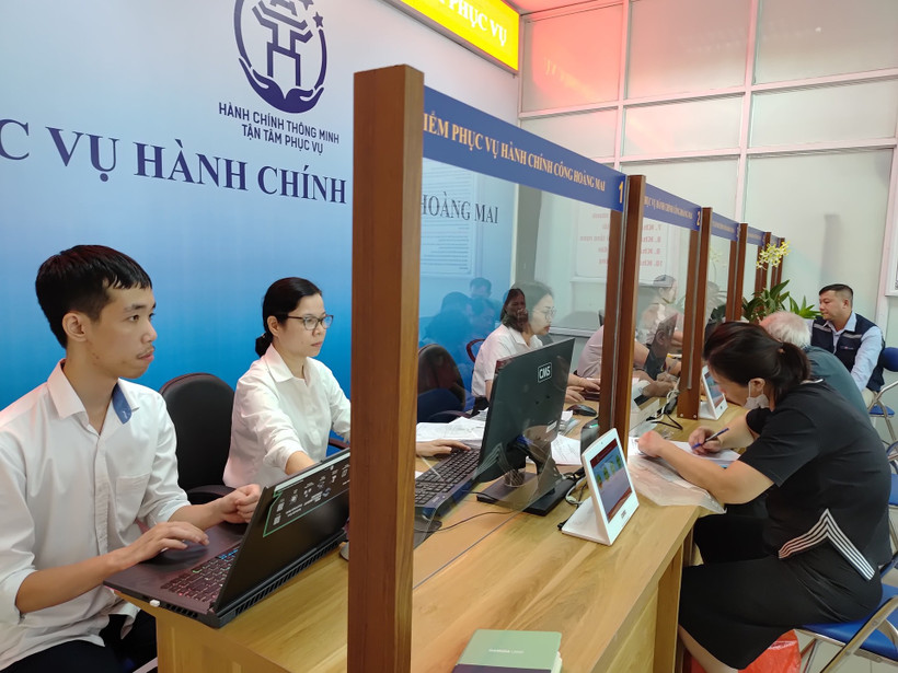 Điểm phục vụ hành chính công Hoàng Mai (Hà Nội), các chuyên viên nhiệt tình hướng dẫn người dân làm thủ tục. (Ảnh HẢI MIÊN)