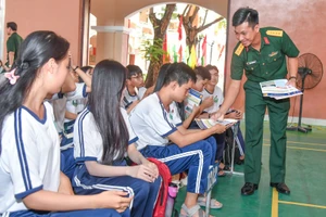 Cán bộ tuyển sinh phát tờ rơi những thông tin cần biết về tuyển sinh quân sự 2026.