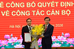 Phó Giáo sư, Tiến sĩ Đoàn Minh Huấn, Ủy viên Bộ Chính trị, Giám đốc Học viện Chính trị quốc gia Hồ Chí Minh trao quyết định bổ nhiệm Giáo sư, Tiến sĩ Nguyễn Quốc Sửu, Phó Giám đốc Học viện Hành chính và Quản trị công (Học viện Chính trị quốc gia Hồ Chí Minh) giữ chức danh trợ lý của đồng chí Đoàn Minh Huấn, Ủy viên Bộ Chính trị, Giám đốc Học viện Chính trị quốc gia Hồ Chí Minh. (Ảnh: PHẠM CƯỜNG)