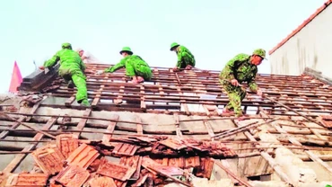 Cán bộ, chiến sĩ Bộ đội Biên phòng tỉnh giúp dân tháo dỡ nhà cũ, dột nát.