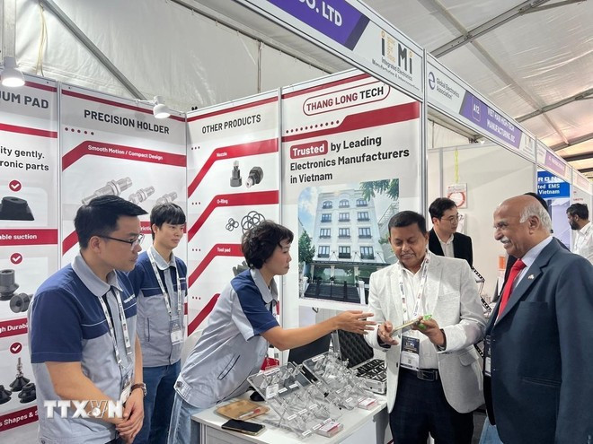 Ông N. Srinivasa Murthy, Lãnh sự Danh dự Việt Nam tại Bangalore (áo đen) và các đại biểu tham quan khu gian hàng Việt Nam. (Ảnh do Thương vụ Việt Nam cung cấp/TTXVN phát)