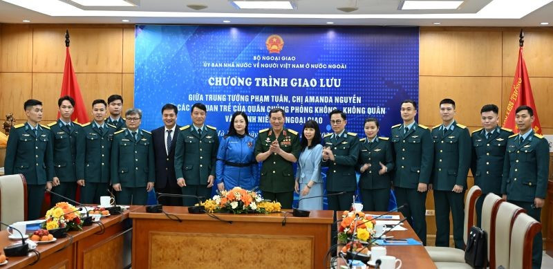 Trung tướng Phạm Tuân và nữ phi hành gia Amanda Nguyễn chụp ảnh kỷ niệm với các đại biểu tham gia giao lưu. (Ảnh: Ủy ban Nhà nước về người Việt Nam ở nước ngoài cung cấp)