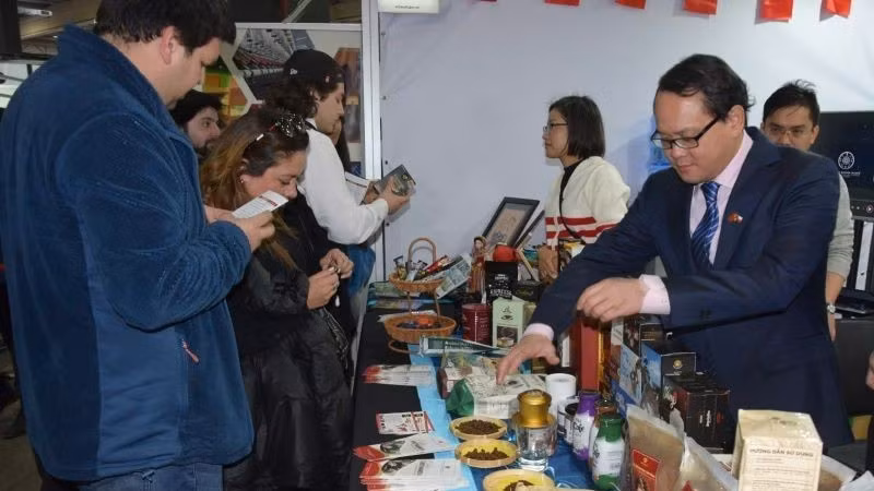 Đại sứ Việt Nam tại Chile Nguyễn Việt Cường giới thiệu các sản phẩm cà-phê của Việt Nam với khách tham quan Hội chợ. (Ảnh: Đại sứ quán Việt Nam tại Chile)