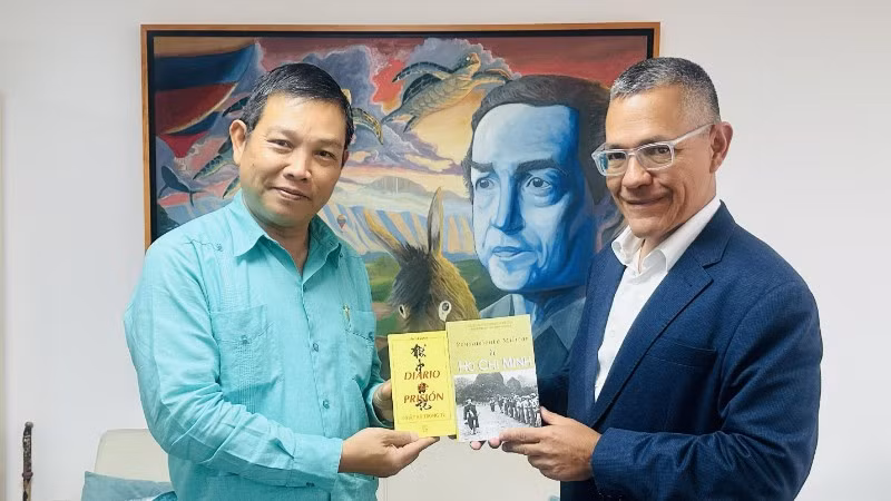 Đại sứ Vũ Trung Mỹ trân trọng chuyển tới Bộ trưởng Ernesto Villegas cuốn Nhật ký trong tù của Chủ tịch Hồ Chí Minh và cuốn Tư tưởng quân sự Hồ Chí Minh. (Ảnh: Đại sứ quán Việt Nam tại Venezuela)