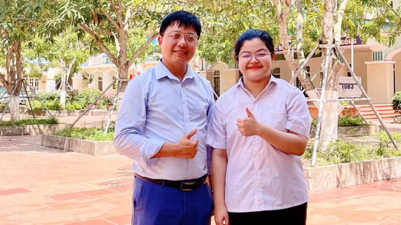 Thí sinh Nguyễn Thái An, học sinh trường THPT Kim Sơn A đạt điểm tuyệt đối 30/30 khối A00 và thầy giáo chủ nhiệm chụp ảnh lưu niệm. (Ảnh: Báo Ninh Bình)