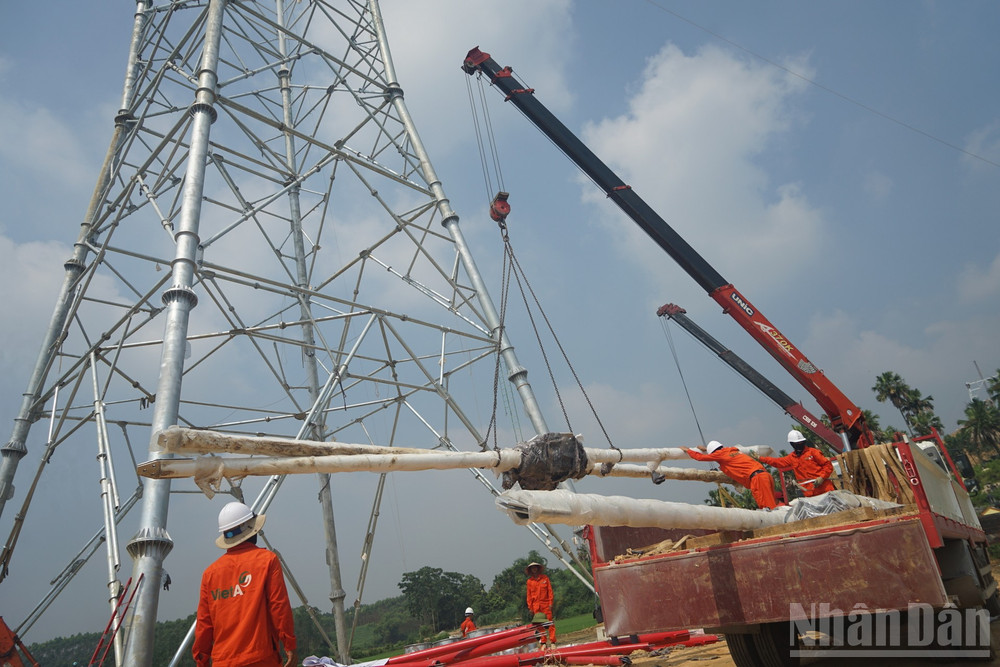 Thiết bị và vật tư siêu trường, siêu trọng được cẩu kéo qua địa hình đồi núi hiểm trở, tập kết tại vị trí lắp đặt. Nhiều vị trí phải sử dụng thiết bị cơ giới hạng nặng để lắp cột thép. (Ảnh: TRUNG HƯNG) ndo_br_dsc02486.jpg