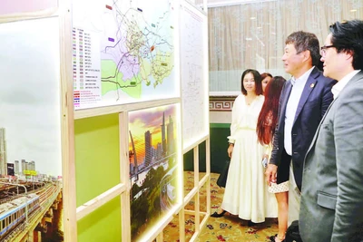 Nhà đầu tư nước ngoài tìm hiểu thông tin về các dự án kêu gọi đầu tư tại buổi gặp gỡ. (Ảnh THẾ ANH)