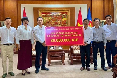 Đại diện Tổng hội người Việt Nam tại Lào ủng hộ đồng bào trong nước chịu ảnh hưởng bão lũ. (Ảnh: Cộng tác viên) 