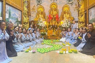 Cộng đồng người Việt Nam tại Lào thắp nến hoa đăng cầu nguyện cho đồng bào. (Ảnh: DUY TOÀN)