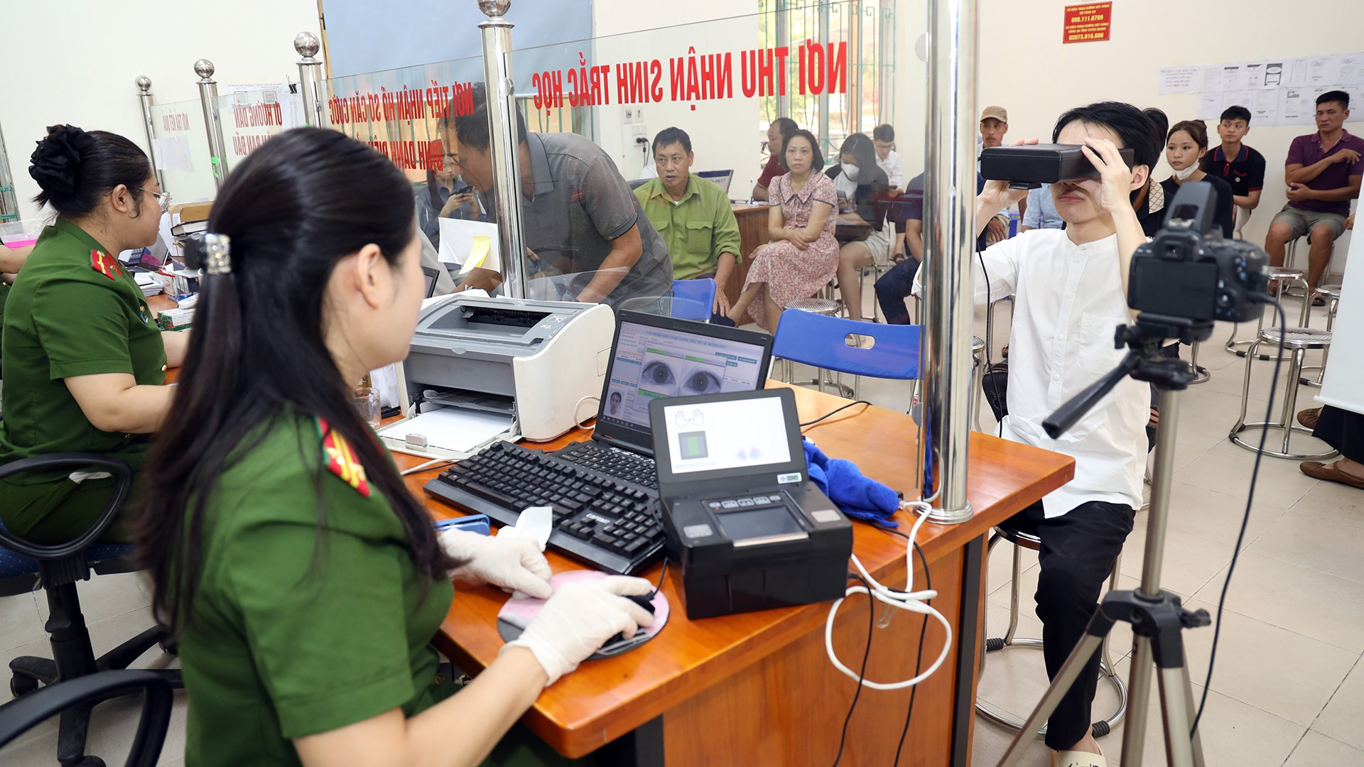 Cán bộ công an hướng dẫn người dân thực hiện quy trình lấy sinh trắc học cấp căn cước lần đầu. tq4.jpg