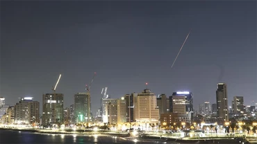 Một vệt sáng (bên phải) xuất hiện trên bầu trời bầu trời Tel Aviv, Israel, khi hệ thống phòng không của nước này phóng tên lửa đánh chặn, ngày 18/6/2025. (Ảnh: Tân Hoa Xã)