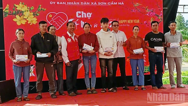 Lãnh đạo xã Sơn Cẩm Hà trao quà cho người dân.