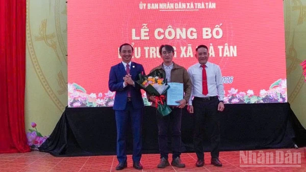 Lãnh đạo xã Trà Tân tặng hoa cho tác giả thiết kế biểu trưng xã Trà Tân.