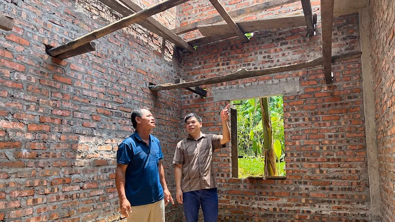 Cán bộ xã Yên Phúc, tỉnh Lạng Sơn (áo kẻ) đến thăm gia đình bà Nông Thị Việt (vợ liệt sĩ) đang được hỗ trợ xây mới nhà ở. 