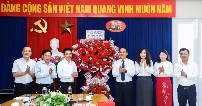 Phó Bí thư Thường trực Thành ủy Nguyễn Đình Vĩnh thay mặt Thành ủy, Hội đồng nhân dân, Ủy ban nhân dân, Ủy ban Mặt trận Tổ quốc Việt Nam thành phố Đà Nẵng tặng hoa chúc mừng.