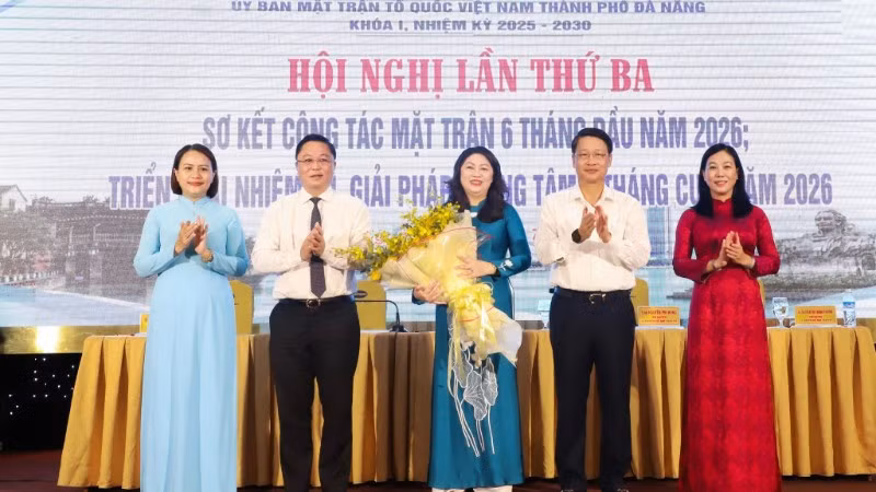 Phó Bí thư Thành ủy Đà Nẵng Ngô Xuân Thắng (thứ 2 bên phải qua) và Chủ tịch Ủy ban Mặt trận Tổ quốc Việt Nam thành phố Đà Nẵng Lê Trí Thanh (thứ 2 bên trái qua) tặng hoa chúc mừng bà Nguyễn Thị Thu Lan.