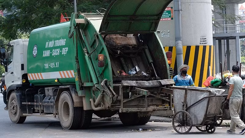 Công nhân Công ty Môi trường đô thị Hà Nội thu gom rác thải ở quận Đống Đa. (Ảnh: PHẠM HÙNG)