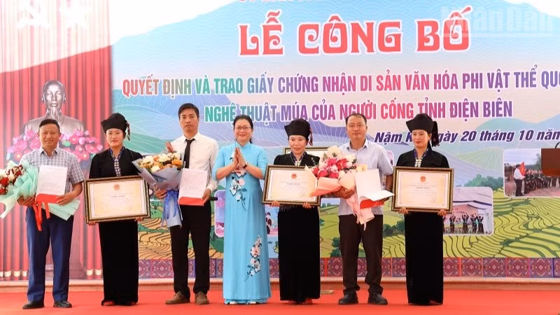 Đồng chí Nguyễn Thị Thanh Chuyên, Phó Giám đốc Sở Văn hóa, Thể thao và Du lịch Điện Biên trao Bằng Công nhận Di sản văn hóa phi vật thể quốc gia cho Nghệ thuật múa của người Cống cho nhân dân dân tộc Cống xã Nậm Kè. (Ảnh: LÊ LAN)