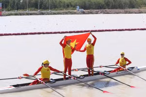 Các tay chèo Việt Nam tự hào giương cao quốc kỳ sau khi cán đích về nhất. 