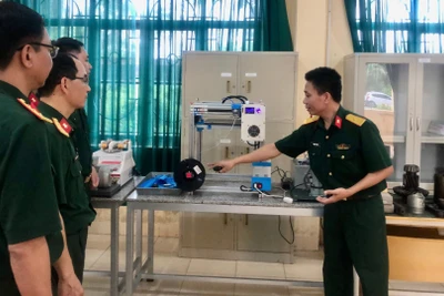 Cán bộ Trường Cao đẳng Kỹ thuật Quân sự 1 giới thiệu mô hình máy in 3D, một sản phẩm ứng dụng công nghệ số trong nghiên cứu khoa học tại đơn vị.