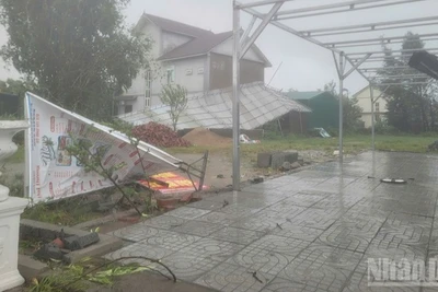 Mái tôn, biển bảng bị gió cuốn nghiêng, đổ ở phường Cửa Lò (Nghệ An). (Ảnh: NGÔ TUẤN)