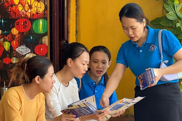 Cán bộ Bảo hiểm xã hội tuyên truyền chính sách bảo hiểm xã hội, bảo hiểm y tế cho người lao động phường Hội An (tỉnh Quảng Nam).