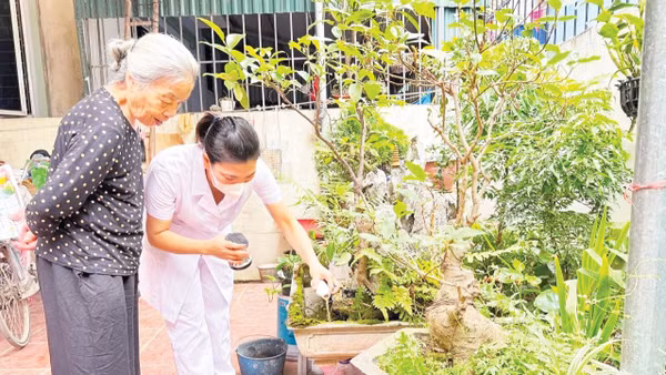Nhân viên y tế hỗ trợ người dân sử dụng hóa chất để phòng, chống dịch sốt xuất huyết.