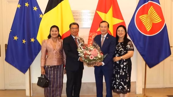 Đại sứ Kingphokeo Phommahaxay (trái) tặng hoa cho Đại sứ Nguyễn Văn Thảo. (Ảnh: HƯƠNG GIANG/TTXVN)