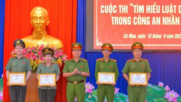 Đại tá Trần Văn Thi, Phó Giám đốc Công an tỉnh Cà Mau (đứng giữa) trao Giấy khen cho nhóm tác giả đạt giải Nhất cấp tỉnh Cuộc thi tìm hiểu Luật Dữ liệu Công an nhân dân.