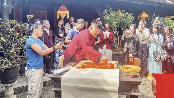 Nghệ nhân Nguyễn Công Đạt thực hiện in liễn làng Chuồn trong không gian Ngự Hà Viên, Huế. (Ảnh: MẠNH HÀO)