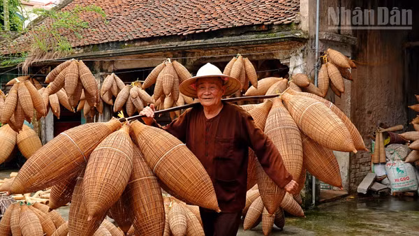 Nghệ nhân Lương Sơn Bạc gánh trên vai những chiếc đó bằng tre. Ảnh: LINH VŨ
