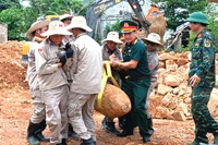 Các lực lượng phối hợp di dời, xử lý quả bom còn sót lại sau chiến tranh. (Ảnh: LA)
